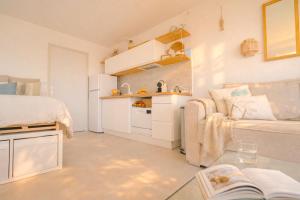 a small white room with a bed and a couch at Vue mer & terrasse Studio calme parking St Raphaël in Saint-Raphaël
