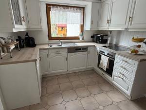 a kitchen with white cabinets and a sink at Ferienwohnung Sensbachtal in Untersensbach