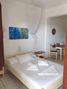a white bed with white pillows on it in a room at Aeolos Hotel Apartments in Gythio