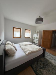 a bedroom with a large bed with white sheets at Ferienwohnung Sensbachtal in Untersensbach