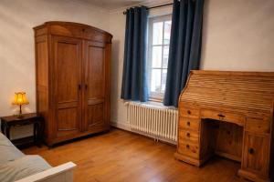 a bedroom with a bed and a dresser and a window at The Old Coach Retreat in Rheinfelden