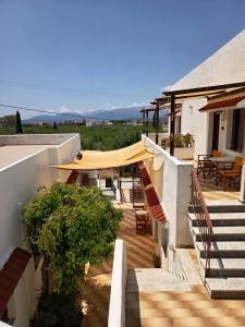 a building with stairs and a patio with tables and chairs at Aeolos Hotel Apartments in Gythio