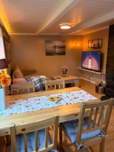 a dining room with a table with chairs and a television at Drangedal Cabin House in Drangedal