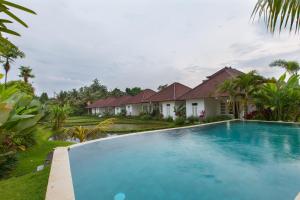 una imagen de una piscina frente a una casa en Abipraya Ubud, en Ubud