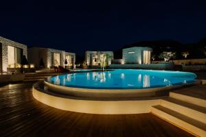 a swimming pool at night with buildings in the background at Kyklio Pavilions in Nafplio