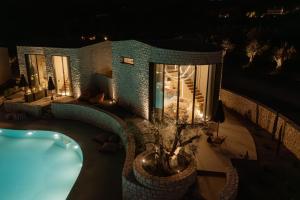 a building with a swimming pool at night at Kyklio Pavilions in Nafplio