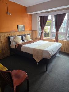 a bedroom with a large bed and a window at Himalayan Meadows in Darjeeling