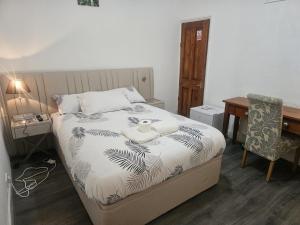 a bedroom with a bed and a desk and a chair at Seraphic Homes Medway Kent in Gillingham