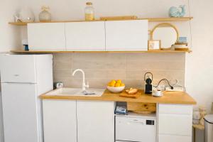a kitchen with white cabinets and a sink at Vue mer & terrasse Studio calme parking St Raphaël in Saint-Raphaël +22 photos