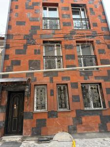a tall brick building with windows and a door at A & A GLOBAL PROPERTY RENTALs in Yerevan