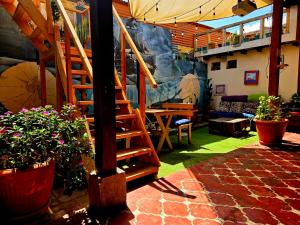 a living room with a staircase and some plants at Amura Hostel - Antigua Guatemala in Antigua Guatemala