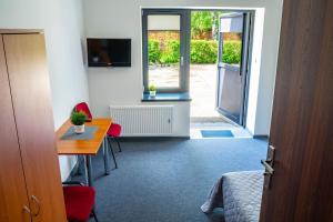 ein Zimmer mit einem Schreibtisch und ein Zimmer mit einer Tür in der Unterkunft Hotel Wołów in Wołów
