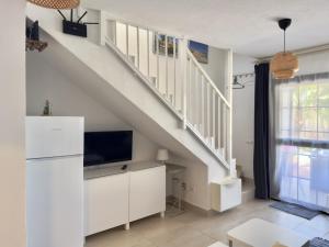 a living room with a tv and a staircase at Casa Hugo in Costa Calma