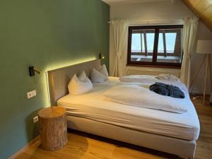 a bedroom with a bed with white sheets and a window at Landhaus Langeck in Münstertal