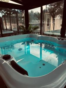 a hot tub in a house with blue water at Villa avec Spa & Sauna, Évasion in Béziers