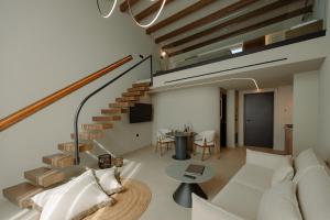 a living room with a white couch and a staircase at Kyklio Pavilions in Nafplio