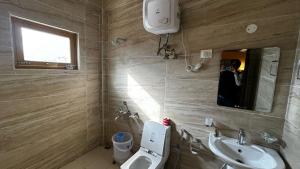 a bathroom with a sink and a toilet and a mirror at Hotel Heritage in Kaza +6 photos