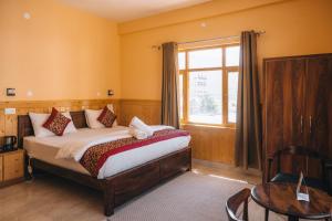 a bedroom with a large bed and a window at Hotel Heritage in Kaza