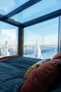 a bedroom with a large window with snowmen outside of it at Arctic Lumo Resort in Kuusamo