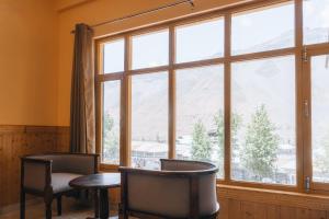 a room with a large window with chairs and a table at Hotel Heritage in Kaza
