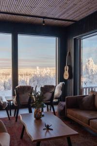 a living room with a view of snow covered mountains at Arctic Lumo Resort in Kuusamo