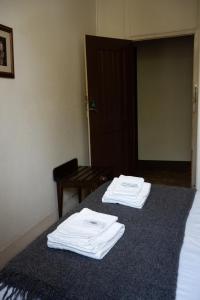 a room with two beds with white towels on them at Corações Unidos "A Pensão" in Alcobaça