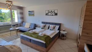 a bedroom with a bed and a living room at Ferienwohnung Naturgenuss in Oy-Mittelberg +18 photos
