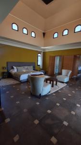 a large room with a bed and chairs and windows at Villa maryama in Marrakesh