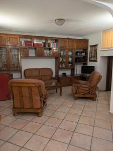 a living room with two chairs and a table at Camera confortevole tra Roma e Ostia in Acilia