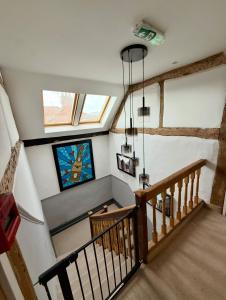 a room with a staircase with a window and a chandelier at City Rooms by Hiive in Worcester
