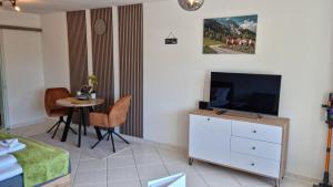 a living room with a television and a table at Ferienwohnung Naturgenuss in Oy-Mittelberg