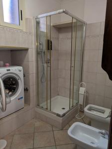 a shower in a bathroom with a toilet and a washing machine at Camera confortevole tra Roma e Ostia in Acilia