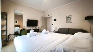 a bedroom with a large white bed and a couch at Gk Central Studio Xanthi in Xanthi
