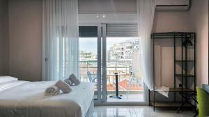 a bedroom with a bed and a view of a balcony at Gk Central Studio Xanthi in Xanthi