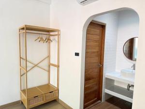 a bathroom with a sink and a wooden door at ชรัส รีสอร์ท เกาะล้าน in Ko Larn