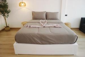 a bed with a pink ribbon on top of it at ชรัส รีสอร์ท เกาะล้าน in Ko Larn