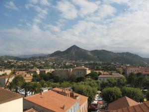 a view of a city with a mountain in the background at Duplex sur la mer in LʼÎle-Rousse