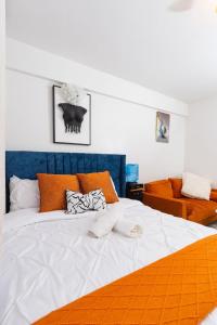 a bedroom with a large white bed with orange pillows at Cynergy Home in Nairobi +17 photos