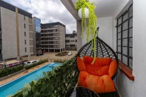 a swing on a balcony with a pool at Cynergy Home in Nairobi