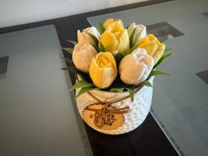 a vase filled with yellow flowers on a table at Apartman Novak Prijedor in Prijedor