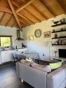 a living room with a couch and a clock on the wall at The Pool House in Longos