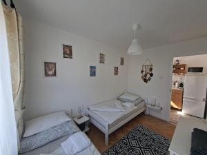 a bedroom with two beds and a refrigerator at Corddora Apartman in Mezőkövesd