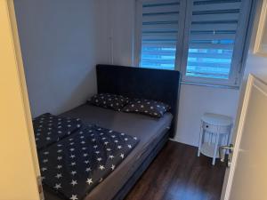 a small bed in a room with a window at Apartman Novak Prijedor in Prijedor