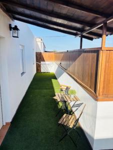 a balcony with two chairs and green grass at Casa Victoria in Antigua +7 photos