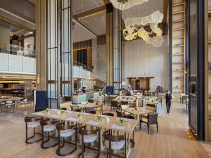 a restaurant with tables and chairs in a building at Pullman Yueyang in Yueyang