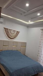 a bedroom with a blue bed and a curtain at villa baya midoun in Midoun