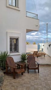 two wooden benches sitting on top of a patio at villa baya midoun in Midoun