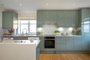 a kitchen with green cabinets and a white counter top at Beacon House in Exmouth