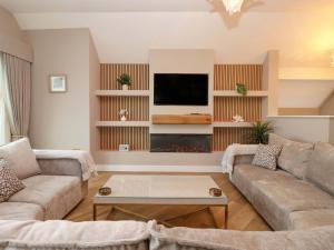 a living room with a couch and a fire place at Swing Bridge Cottage in Brandesburton