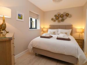 a bedroom with a large bed and two lamps at Swing Bridge Cottage in Brandesburton
